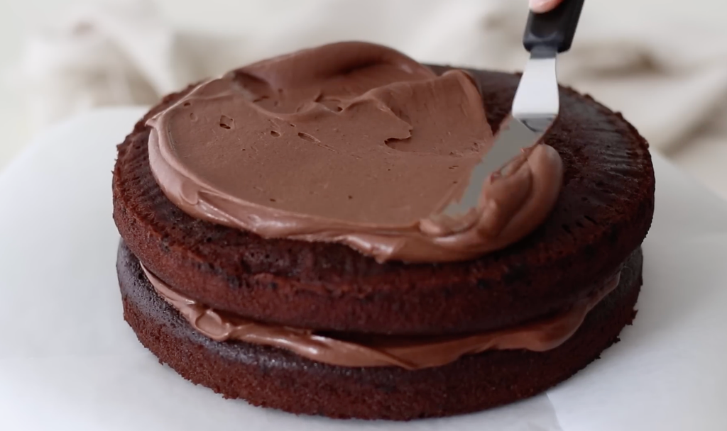Ultra-moist homemade chocolate cake with rich chocolate buttercream frosting and layered chocolate cake slices.